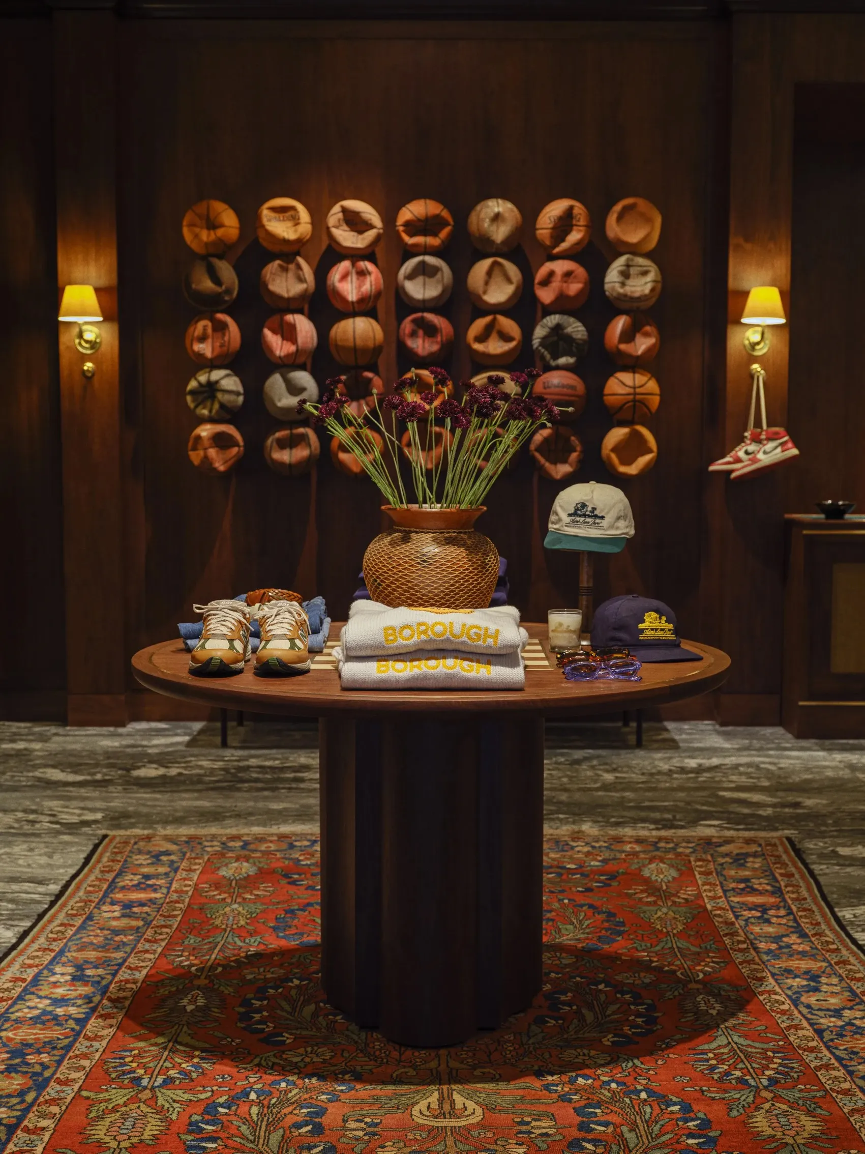 Boutique interior with a round display table and a wall of caps